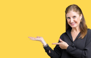 Güzel orta yaş olgun iş kadını üzerinden hayran ve el ile sunulması ve parmak ile işaret ederken kameraya gülümseyen izole arka plan.