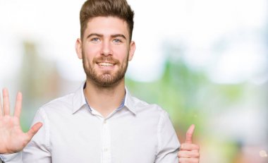 Gösterilen ve parmakları ile işaret genç yakışıklı iş adamı kendinden emin ve mutlu gülümseyerek süre 6 numara.