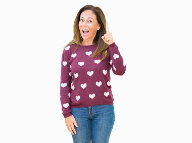 Başarılı fikirle parmağı yukarıyı izole arka plan üzerinde güzel orta yaş kadın giyiyor kalpler kazak. Çıktıktan ve mutlu. Bir numara.