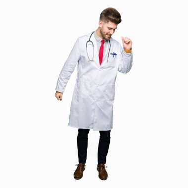 Tıbbi giyen genç yakışıklı Doktor adam rahat ve kendinden emin müzik hareket gülümseyerek dans mutlu ve neşeli, kat