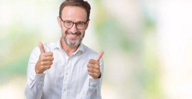 El ile pozitif jest yapıyor izole arka plan başarı işareti üzerinde gözlük takan yakışıklı orta yaş zarif üst düzey iş adamı başparmak gülümseyen ve mutlu. Neşeli bir ifadeyle, kazanan jest kameraya bakıyor.