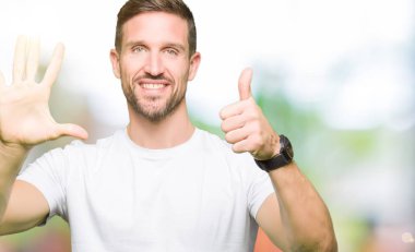Yakışıklı adam gösterilen ve parmakları ile işaret casual beyaz t-shirt giyen süre kendinden emin ve mutlu gülümseyerek 6 numara.