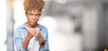 Güzel genç Afro-Amerikan kadın gözlük izole arka plan üzerinde yumruk savunma hareketi, kızgın ve üzgün yüz, sorunu korkuyor ile savaşmaya hazır