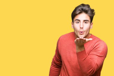 Yakışıklı delikanlı bir öpücük el ile güzel ve seksi olmak hava üfleme kamera bakarak izole arka plan üzerinde. Aşk ifade.