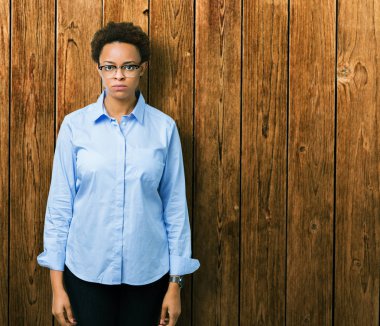 Genç güzel Afro-Amerikan iş kadını izole arka plan şüpheci ve sorun nedeniyle gergin, papatyanın üzgün. Negatif kişi.