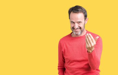 Yakışıklı orta yaş ağarmış komuta sizde giyen kış kazak izole arka plan üzerinde Beckoning gel burada mutlu ve gülümseyerek el davet ile jest