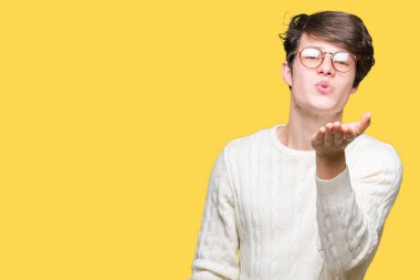 Bir öpücük el ile güzel ve seksi olmak hava üfleme kamera bakarak izole arka plan üzerinde gözlük takan yakışıklı delikanlı. Aşk ifade.