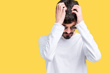 Yakışıklı delikanlı çünkü umutsuz ve stresli baş ağrısı acı izole arka plan üzerinde güneş gözlüğü takıyor ağrı ve migren. Ellerini kafasına.