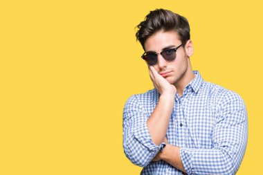 Yakışıklı delikanlı seyir yorgun ve bıkkın ile depresyon sorun Çapraz kollar ile izole arka plan düşünme üzerinde güneş gözlüğü takıyor.