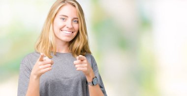 Fotoğraf makinesi ile mutlu ve komik yüz için parmakları işaret izole arka plan üzerinde büyük boy rahat t-shirt giyen güzel ve genç birbayan. İyi enerji ve vibes.