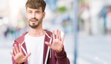 Genç yakışıklı adam şokta bağırarak korkuyor ve dehşet korku ifade dur hareketi el ile ile izole arka plan üzerinde. Panik kavramı.