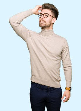 El hareketi ile kendine güvenen dokunaklı saç gülümseyerek, çekici poz gözlüklü genç yakışıklı iş adamı