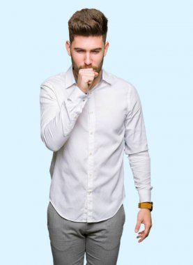 Genç yakışıklı iş adamı kendini iyi hissetmiyor ve soğuk algınlığı veya bronşitin belirtisi olarak öksürüyor. Sağlık hizmetleri kavramı.