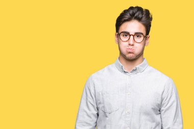 Komik surat ile yanakları şişirme izole arka plan üzerinde gözlük takan yakışıklı delikanlı. Ağız ile hava, deli ifade şişirilmiş.