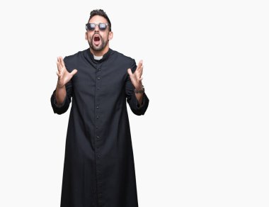 Genç Hıristiyan rahip giyen izole arka plan deli üzerinde güneş gözlüğü ve kızgın bağırarak ve agresif ifade ve silah kaldırdı bağırıyordu. Hayal kırıklığı kavramı.