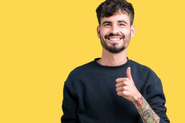 Yakışıklı delikanlı hareketi el ile mutlu yaşasın yapıyor izole arka plan üzerinde. Başarı gösteren kameraya bakarak ifade onaylama.