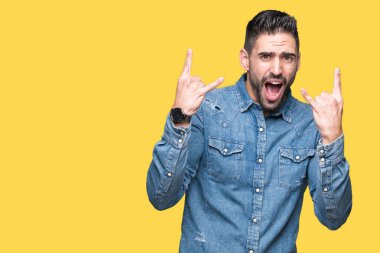 Yakışıklı delikanlı deli ifade rock simge elle yapıyor ile bağırarak izole arka plan üzerinde. Müzik yıldızı. Ağır kavramı.