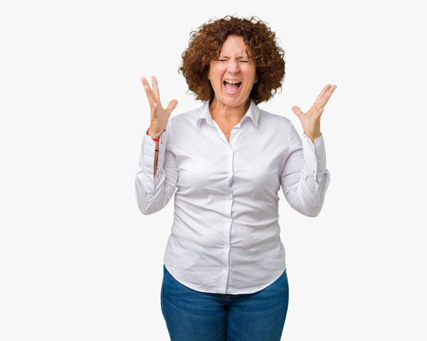 Beautiful middle ager senior businees woman over isolated background celebrating mad and crazy for success with arms raised and closed eyes screaming excited. Winner concept