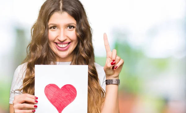 Joven Mujer Adulta Sosteniendo Tarjeta Con Corazón Rojo Sorprendido Con — Foto de Stock