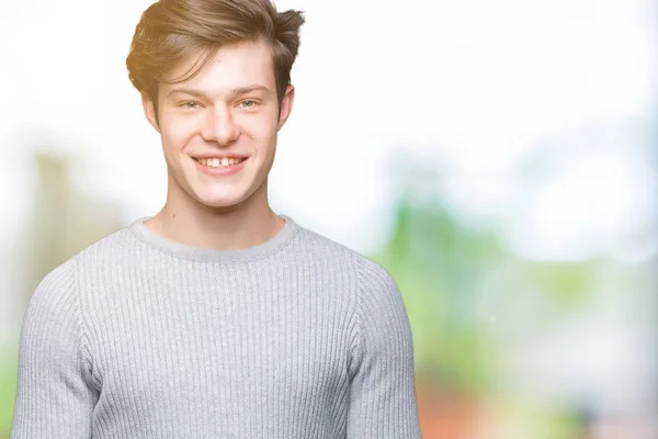 若いハンサムな男の顔に幸せとクールな笑顔で孤立した背景に冬のセーターを着ています 幸運な人 — ストック写真