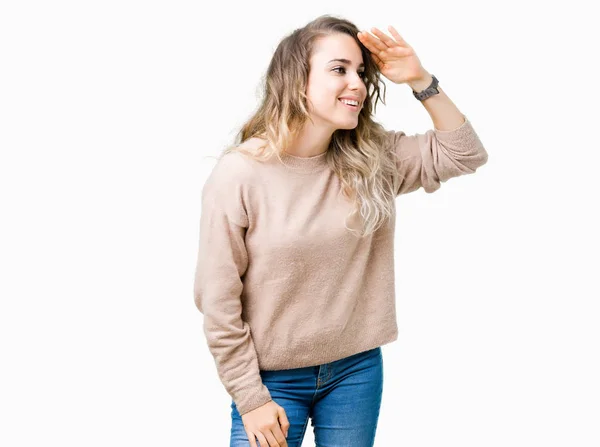 孤立した背景の上にセーターシャツを着た美しい若いブロンドの女性は非常に幸せで 頭の上に手で遠くに見て笑顔 概念の検索 — ストック写真