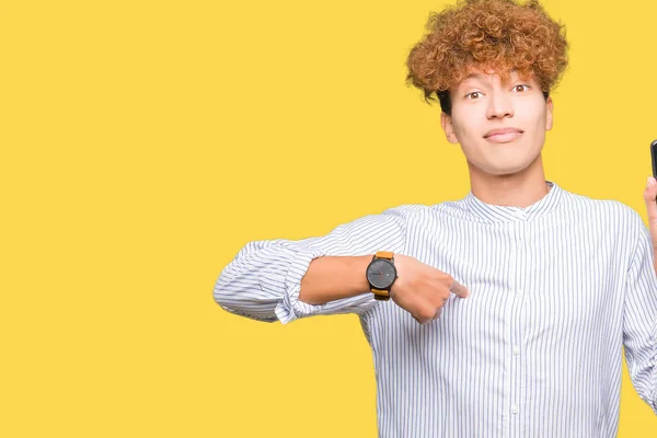 Young handsome man showing smartphone screen with surprise face pointing finger to himself