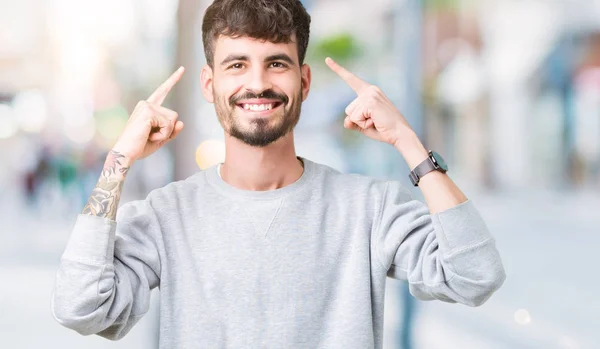 Joven Hombre Guapo Usando Sudadera Sobre Fondo Aislado Sonriendo Señalando — Foto de Stock