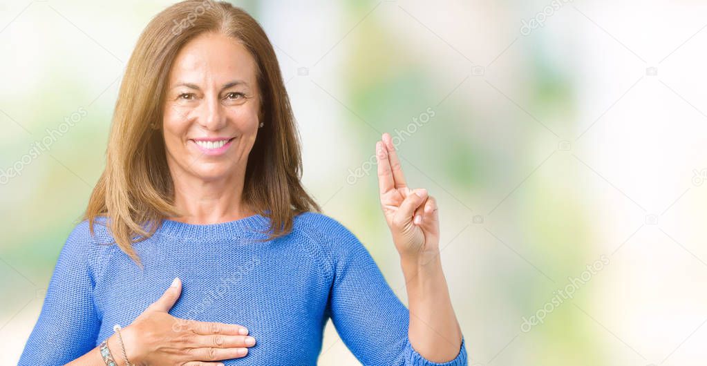 Middle age beautiful woman wearing winter sweater over isolated background Swearing with hand on chest and fingers, making a loyalty promise oath