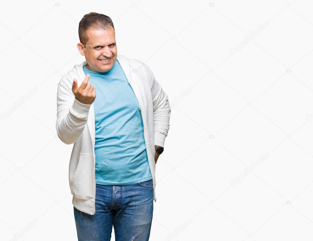 Middle age arab man wearing sweatshirt over isolated background Beckoning come here gesture with hand inviting happy and smiling