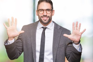Genç yakışıklı iş adamı gösterilen ve parmakları ile işaret izole arka plan üzerinde kendinden emin ve mutlu gülümseyerek süre on numara.