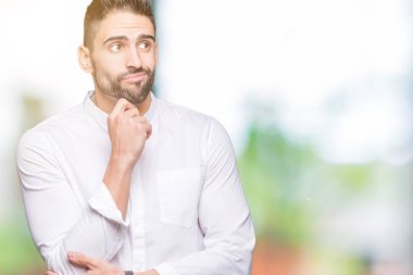 Çene düşünme hakkında soru, dalgın ifade üzerine el ile izole arka plan üzerinde genç iş adamı. Düşünceli yüzüyle gülümsüyor. Şüphe kavramı.