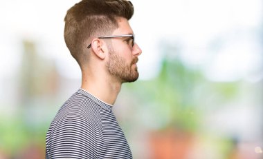 Yan, doğal yüz emin gülümseme ile pozuyla profil rahatla aramaya giyen güneş gözlüğü genç yakışıklı adam.