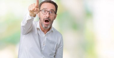 Üzerinde gözlük takan yakışıklı orta yaş zarif üst düzey iş adamı izole arka plan ile sürpriz devam parmakla, açık ağız hayret ifadesi, önünde bir şey