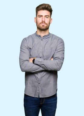 Genç yakışıklı iş casual adam şüpheci ve sinir, onaylamayan ifade yüz çapraz kolları üzerinde. Negatif kişi.