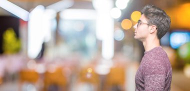 Genç yakışıklı adam gözlük izole arka tarafına, seyir üzerinde dinlenmek doğal yüz emin gülümseme ile pozuyla profili.