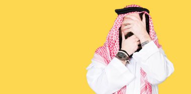 Arap iş adamı geleneksel keffiyeh giymiş uzun saçlı kapsayan gözleri eşarp ve şaşırttı ve şok ellerle ağız. Duygu gizleme
