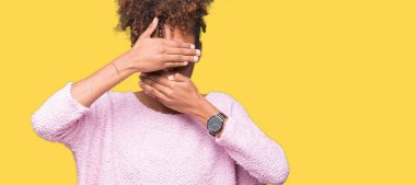 Güzel genç Afro-Amerikan kadın izole arka plan kaplaması gözler ve ağız el ile üzerinden gözlük takan şaşırttı ve şok. Duygu gizleme