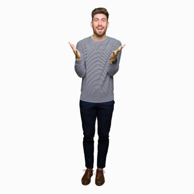 Giyen genç yakışıklı adam kazak kutluyor deli çizgili ve çığlık kaldırdı ve açık gözleri hayret silah ile başarı için heyecanlı. Kazanan kavramı