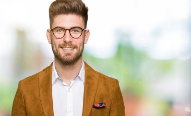 Yüzünde mutlu ve güzel bir gülümseme ile gözlük takan genç yakışıklı iş adamı. Şanslı kişi.