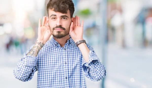 耳ジェスチャー ゴシップに興味津 の両方の手を聞くしようとすると 分離の背景に若いハンサムな実業家難聴 聴覚障害者 — ストック写真
