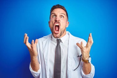 İzole edilmiş arka plan üzerinde beyaz profesyonel ceket giyen genç yakışıklı doktor kızgın ve deli gibi bağırıyor ve agresif bir ifade ve kollarla bağırıyor. Hayal kırıklığı konsepti.