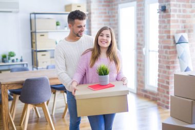 Yeni ev, yeni bir daire için çok mutlu ve neşeli karton kutular tutarak hareket aşk genç güzel çift