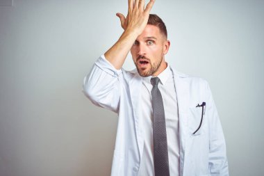 İzole edilmiş arka planda beyaz kürk giyen yakışıklı genç doktor hata için el ele tutuşarak şaşırdı. Hatayı hatırla. Unuttum, kötü hafıza konsepti.