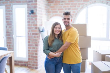 Yeni eve hareketli karton kutular etrafında aşık genç güzel çift, yeni daire için çok mutlu ve neşeli gülümseyen