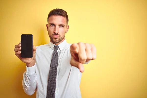 Młody Przystojny Biznesmen Pokazujący Ekran Smartfona Nad Żółtym Odizolowanym Tłem — Zdjęcie stockowe