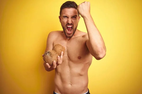 Young Handsome Shirtless Man Holding Exotic Tropical Coconut Isolated Yellow — Stock Photo, Image