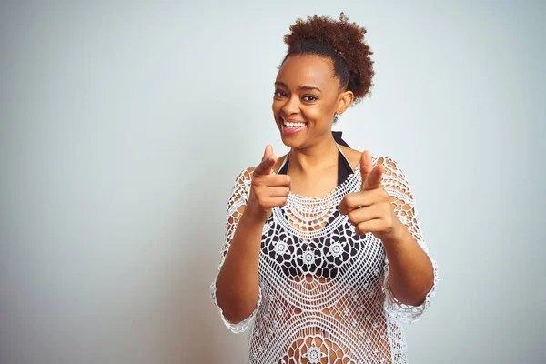 Young african american woman with afro hair wearing a bikini over white isolated background pointing fingers to camera with happy and funny face. Good energy and vibes.