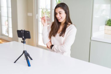 Akıllı telefon web kamerası ile selfie videosu kaydeden güzel genç kadın el ve parmak la yan yana işaret çok mutlu