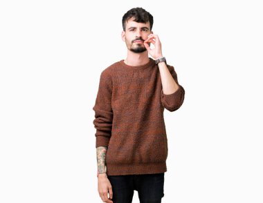 Üzerinde kış kazak giyen genç yakışıklı adam arka plan ağız izole ve parmak ile ZIP olarak dudaklarını kapa. Gizli ve sessiz, tabu söz