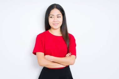İzole arka plan üzerinde kırmızı t-shirt giyen güzel esmer kadın yan görünümlü gülümseyerek ve düşünme uzak bakıyor.